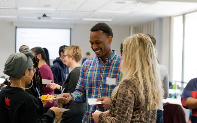 A group of people talking at a presentation