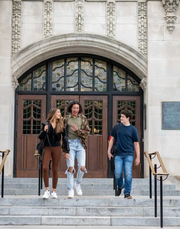 People laughing and talking walking down outside of the Law Quad