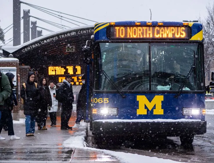 People getting on a U-M bus in the snow